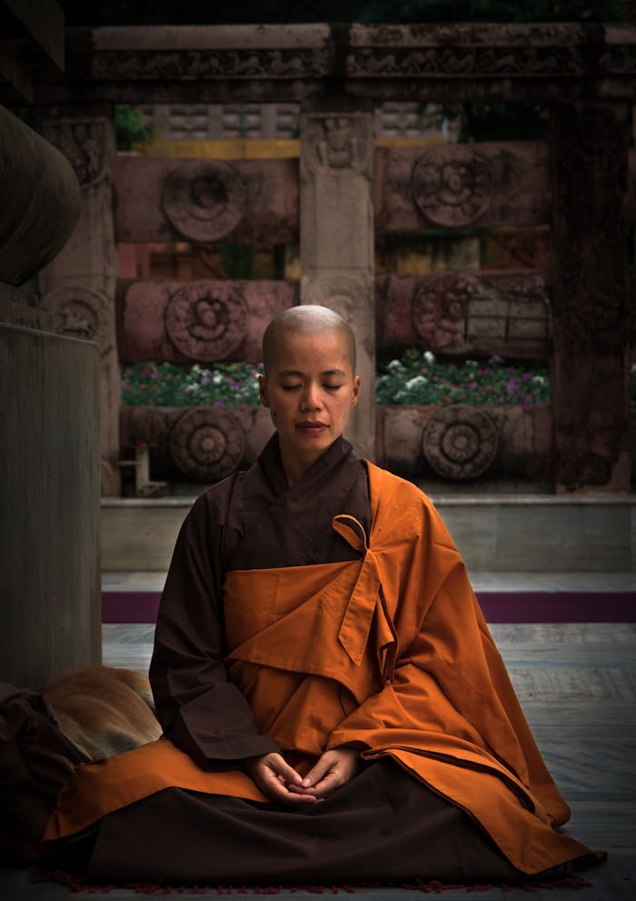 A monk meditating in a temple wearing traditional robes, embodying tranquility and spirituality.